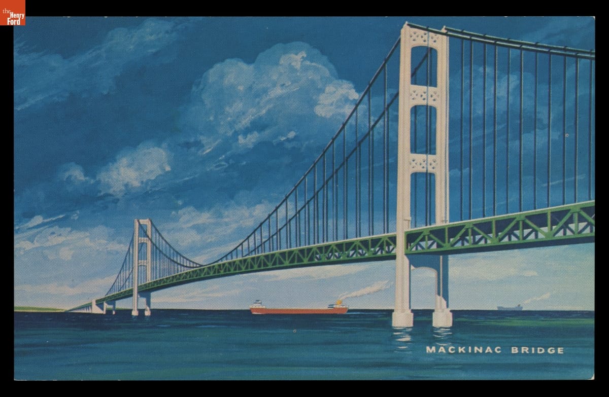 Long white suspension bridge over bright blue water