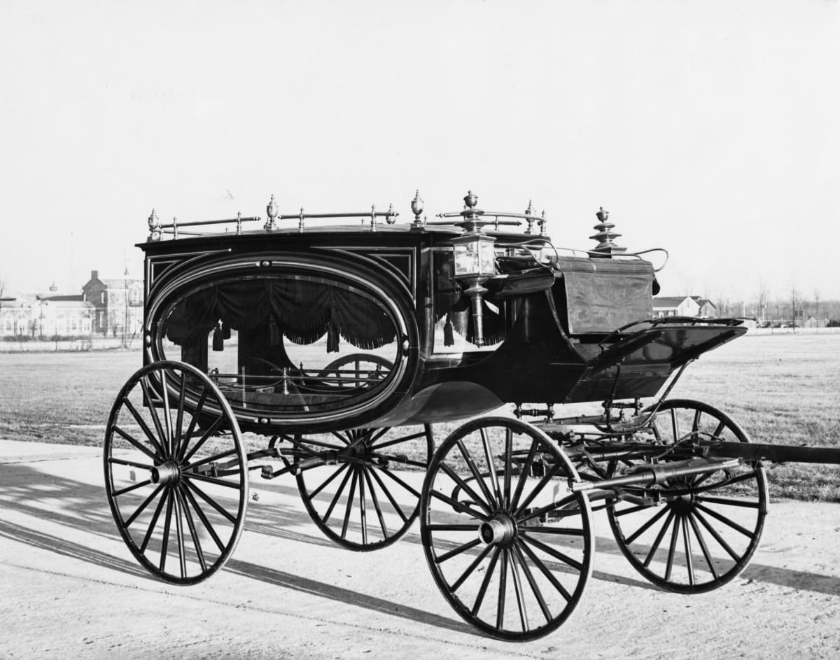 Carriage with large oval window topped with curtain on side