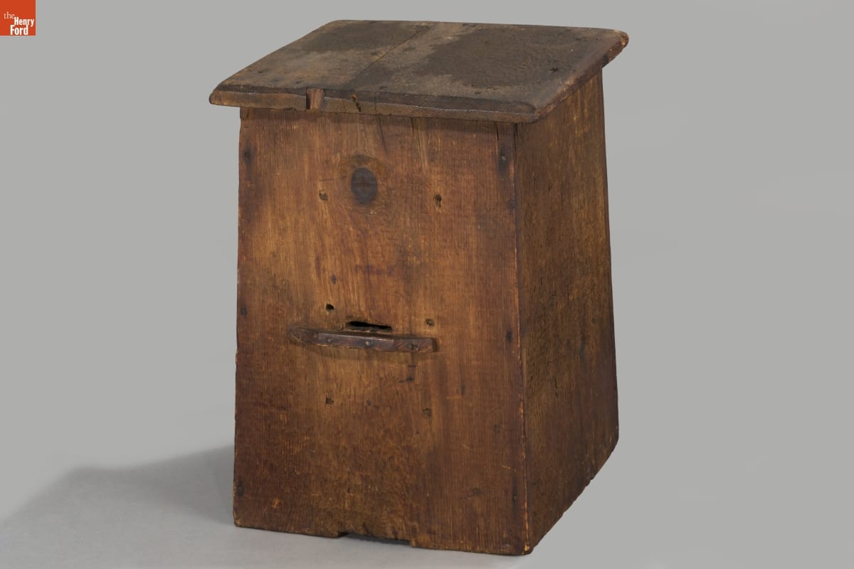 Roughly rectangular wooden box with wooden lid on top