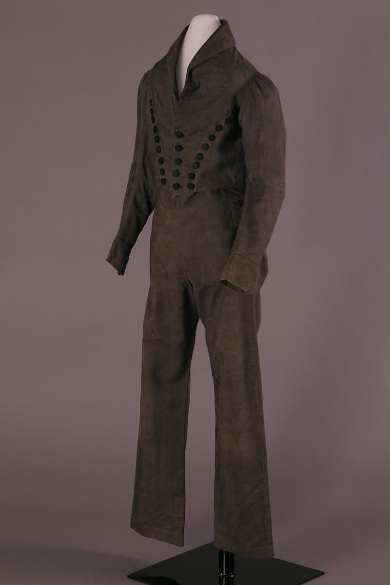 Dark gray suit with simple pants and a jacket with several rows of large black buttons converging at the waist in a W shape