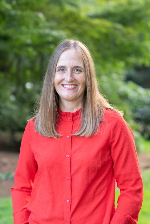Image of woman with long blonde hair in a long-sleeved red shirt.