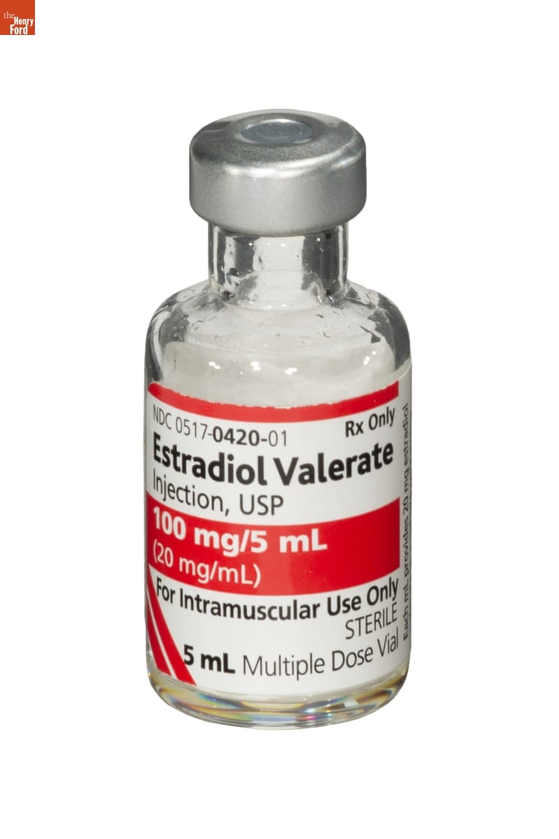 Small glass prescription bottle with silver cap and white and red label containing text