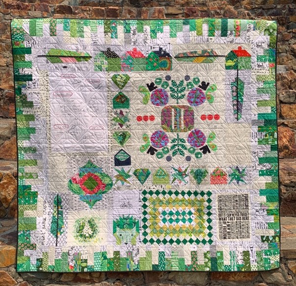 Quilt, primarily white with green border.