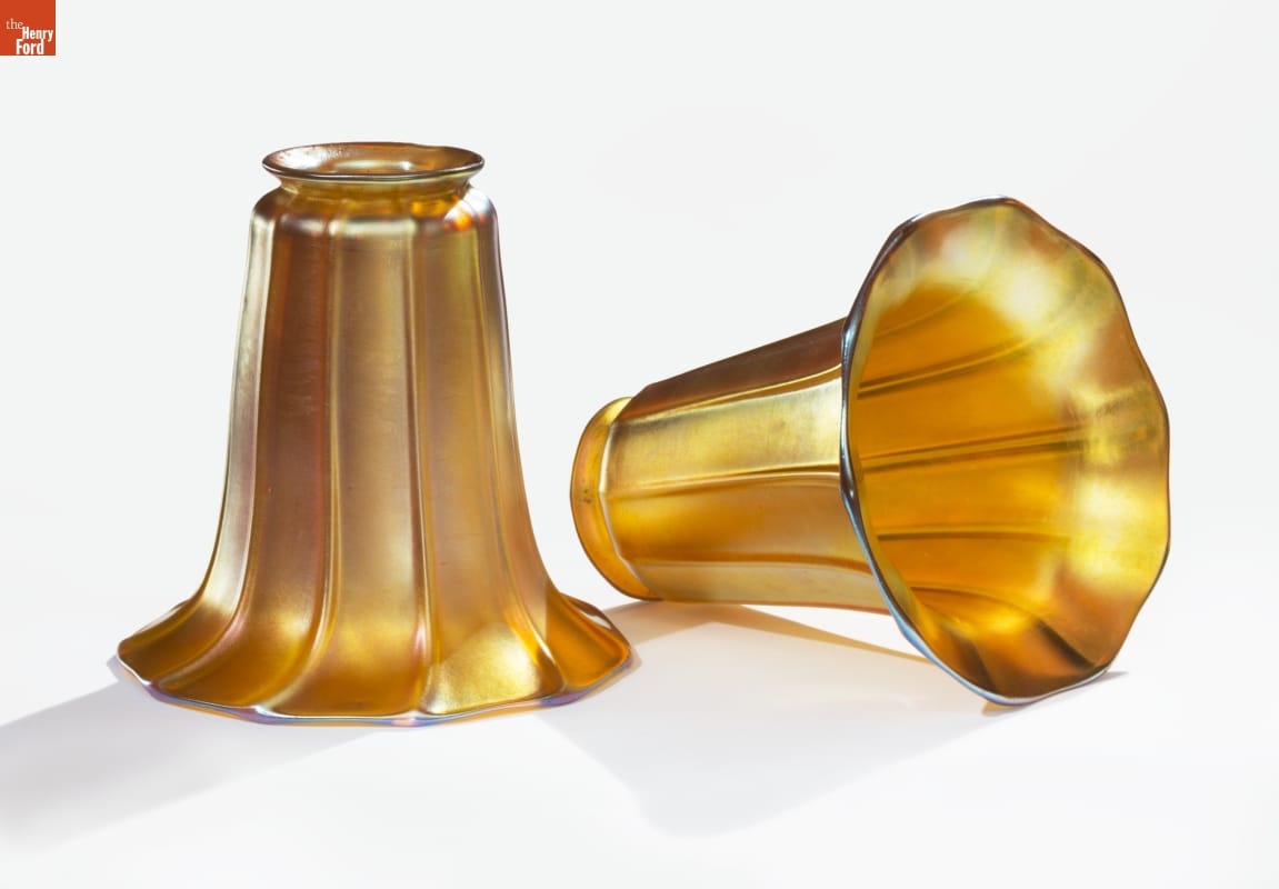 Lampshades, 1905-1910 Two trumpet-shaped lampshades in iridescent gold, one laying on side and one upright