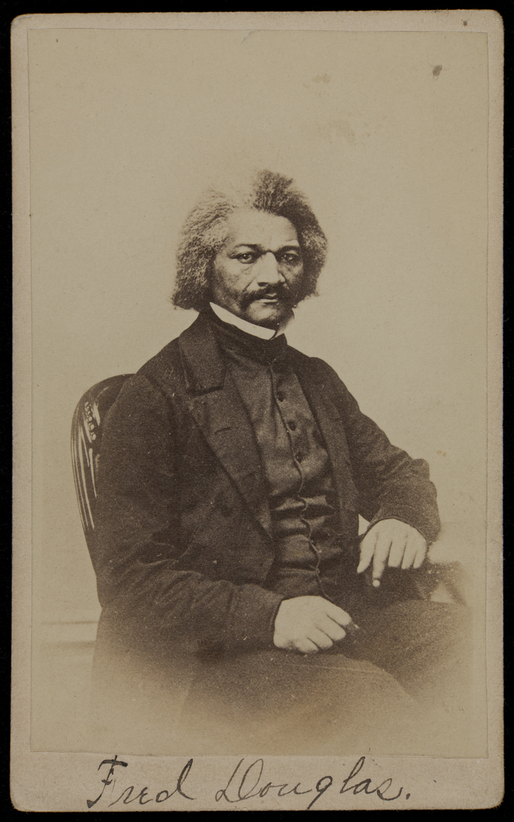 Sepia image of African American man in a suit seated in a chair; “Fred Douglas” handwritten along bottom