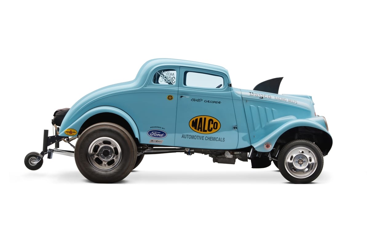 Baby blue race car with shark fin on hood, fifth wheel in back, and logos on side