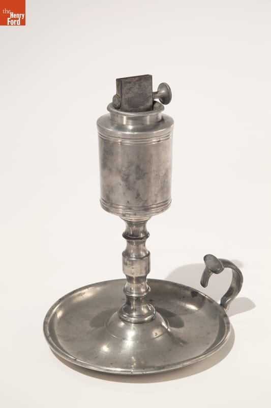 Silver table lamp with base, stem, and loop for carrying