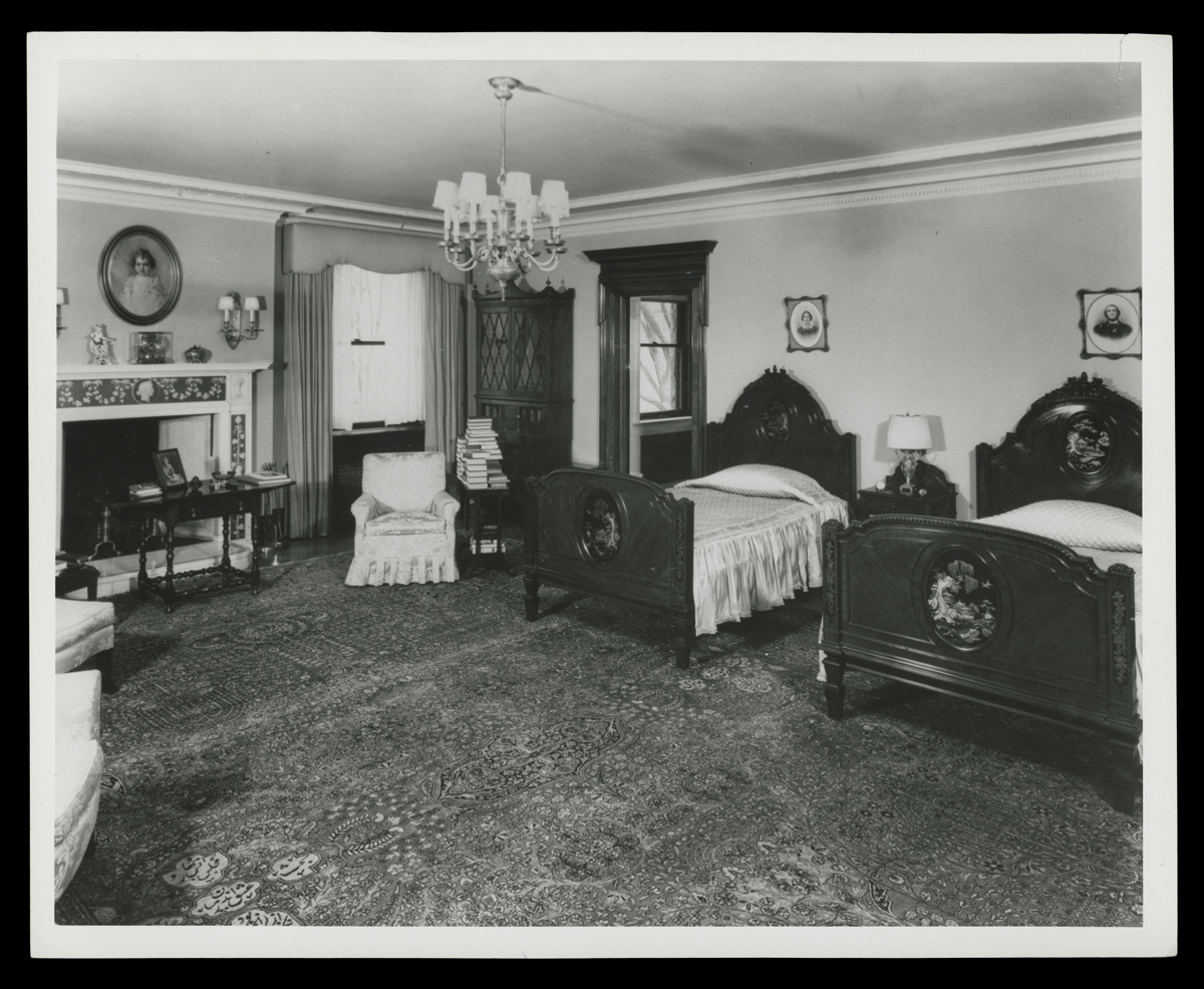 Bedroom interior with two twin beds, a fireplace, and other furniture