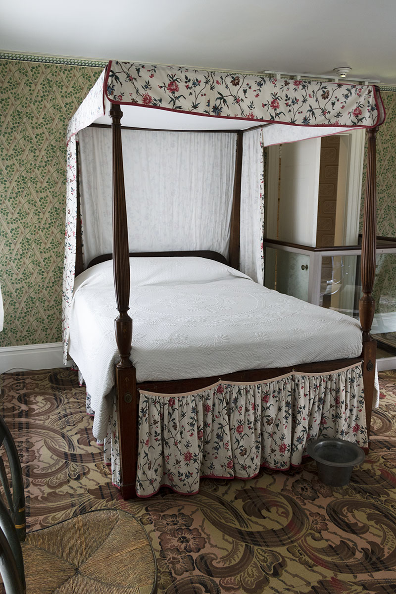 Noah Webster Home / guest bed room view Canopy bed in a room with patterned carpet and wallpaper