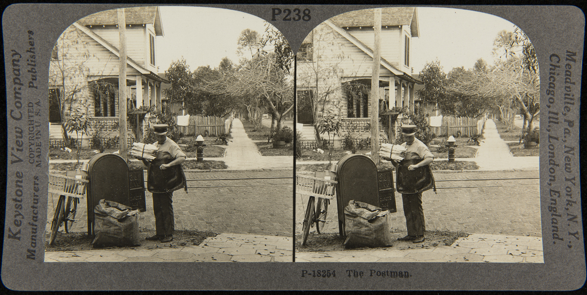 Double arch-shaped image of postman by mailbox on a residential street adding items to mailbag; a bike leans against postbox and a large sack is nearby