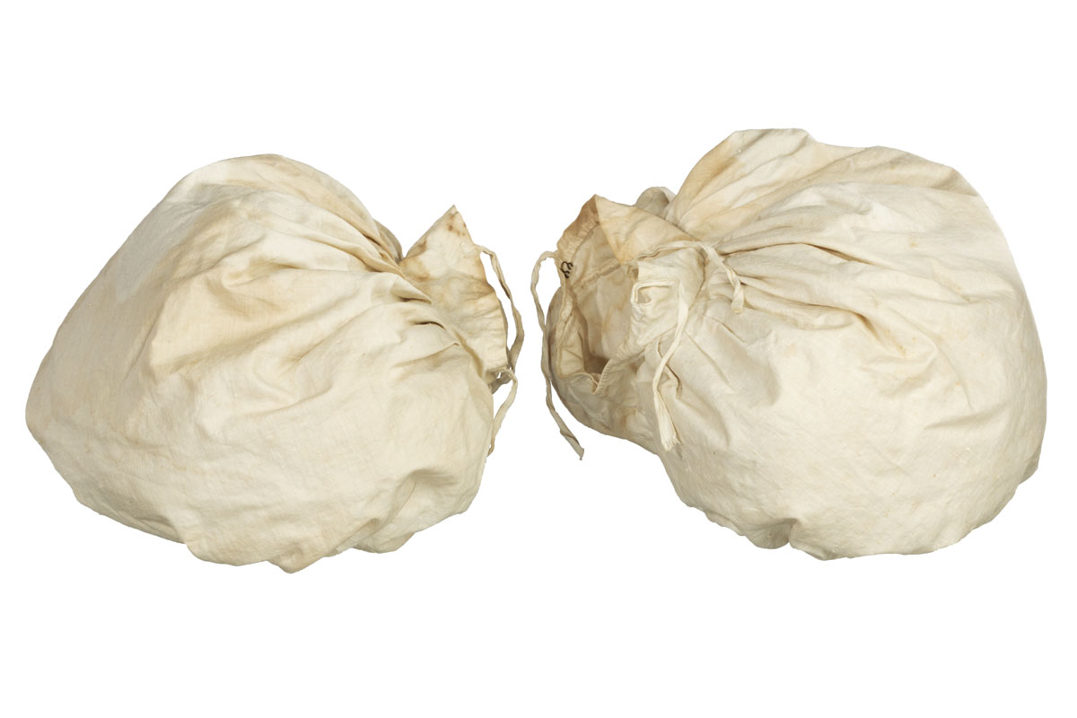 White sacks filled with something and gathered with ribbon at necks