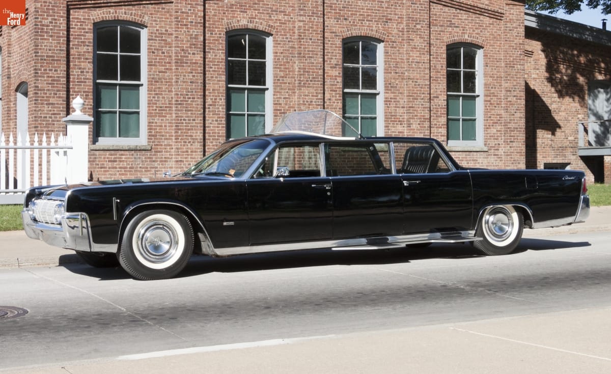 Lincoln Continental Stretch Limousine, Used by Various Dignitaries in New York City and Chicago, 1964-1965 Black limousine parked outside a red brick building