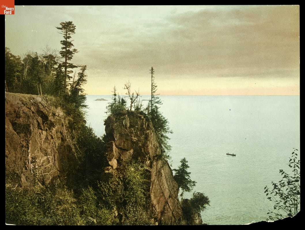 Bluffs with pine trees overlook a large body of water