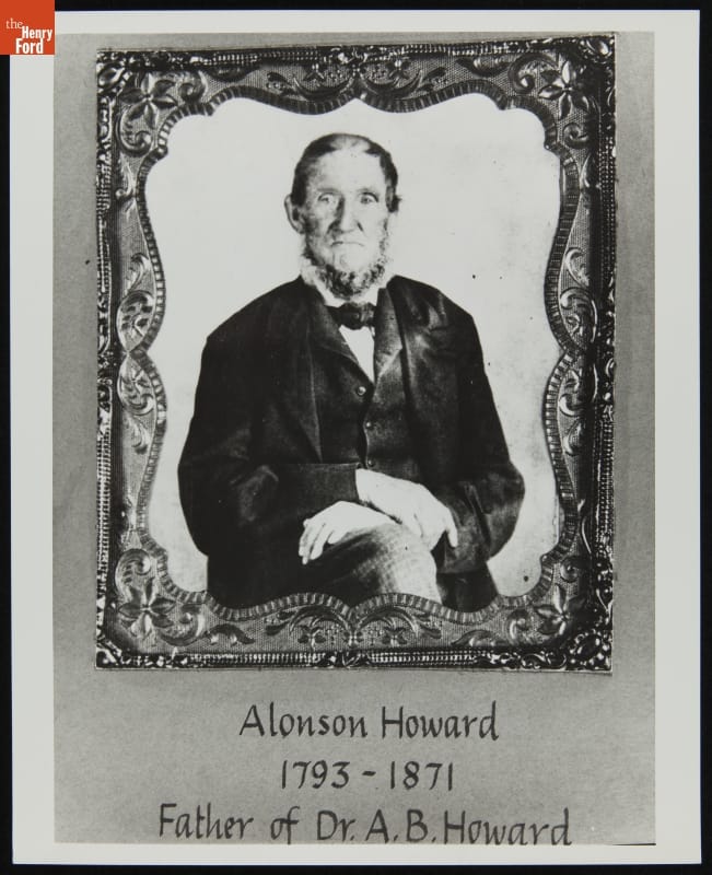 Portrait of man in suitcoat, jacket or vest, and tie, sitting with hands crossed on knee, in intricate frame; also contains text
