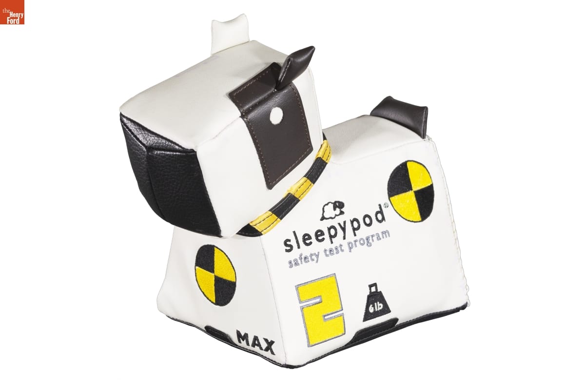 Boxy leather or plastic dog figure, with text, logos, and shapes on sides