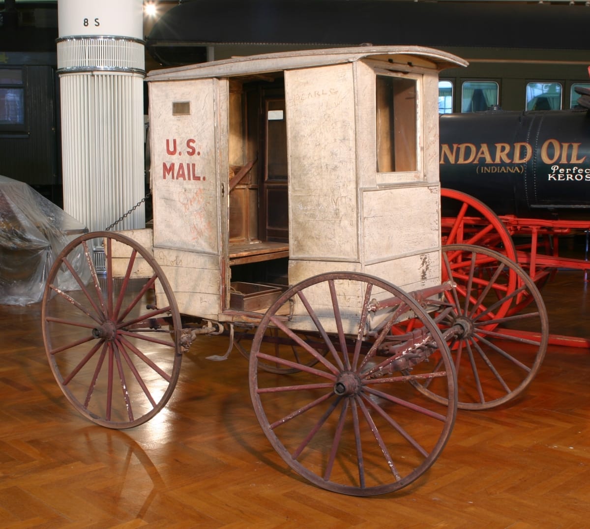 Small, boxy carriage with open doorway and text "U.S. MAIL" on side