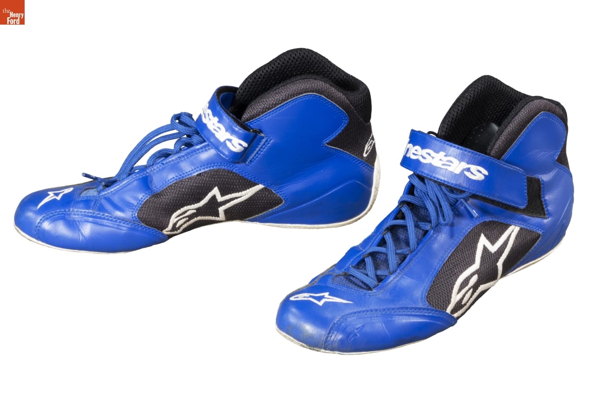 Blue sneakers with blue laces and a black patch containing an extended letter "A" and a star on the outside 