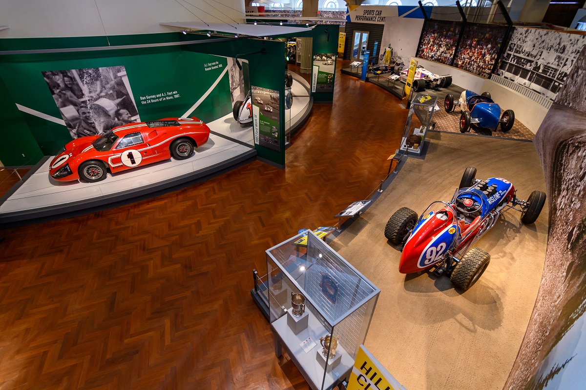 Driven to Win: Racing in America presented by General Motors Aerial shot of museum exhibit featuring cars, along with other artifacts and graphic panels with images and text