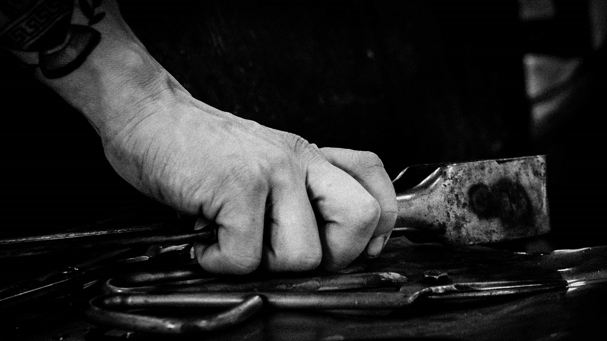 Working in Liberty Craftworks Black-and-white photo of hand clutching tool with other tools nearby
