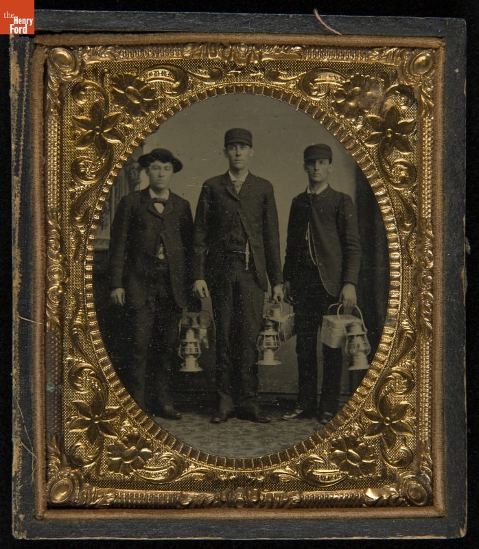 Three Railroad Workers Holding Lanterns and Lunch Pails, circa 1883 Intricate gold frame with black-and-white image of three men in suits and hats holding lanterns and lunch pails